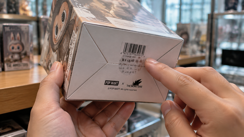 Konsumen memeriksa segel kemasan dan kode barcode sebelum membeli produk blind box mainan anak.