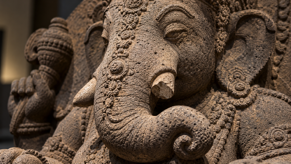 Tampilan makro ukiran mendetail pada bagian belalai dan taring arca Ganesha yang terbuat dari batu andesit.